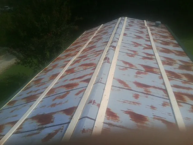 Rusted metal roof panels with new wood purlins before replacement — Storm Damage Roof Repair in Solomon by Roofing Brothers