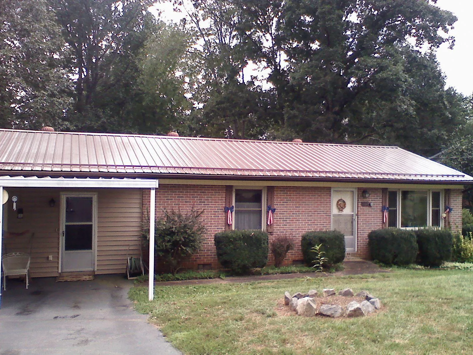 Bronze metal roof and carport on a brick ranch home — Roof Repair work by our crew in Solomon